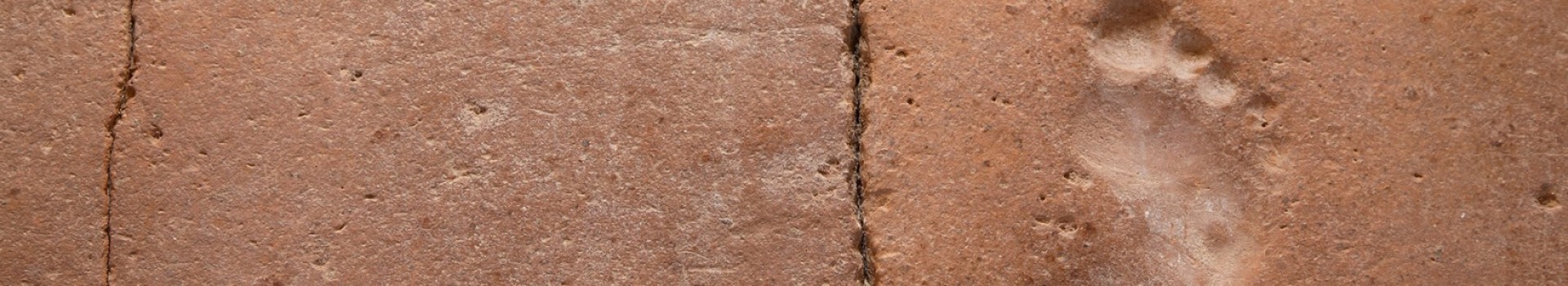 A child's footprint in an ancient tile.