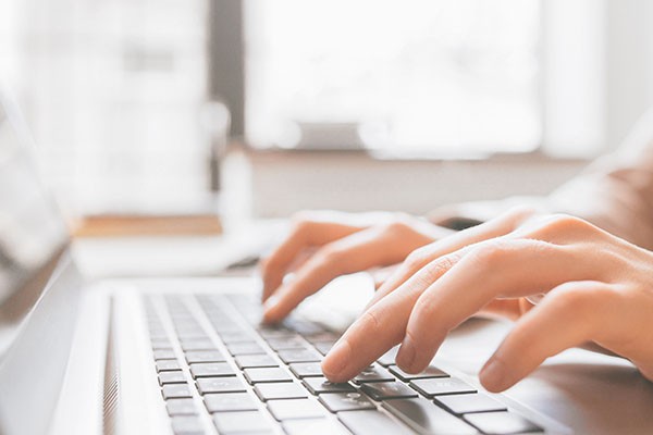 Hands typing at a keyboard.