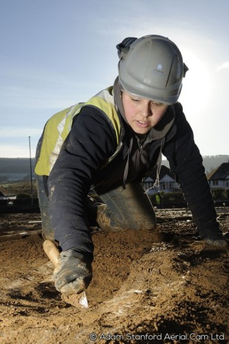 An archaeologist excavates on site.