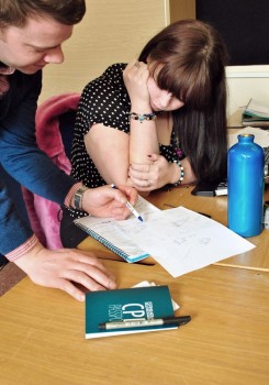 A woman sits at a table and is guided through a CPD document.