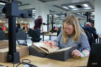 A researcher examines an old document in an archive.